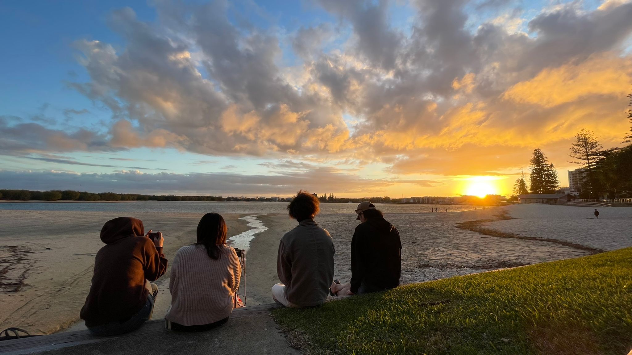 Varias personas comparten un atardecer en la costa